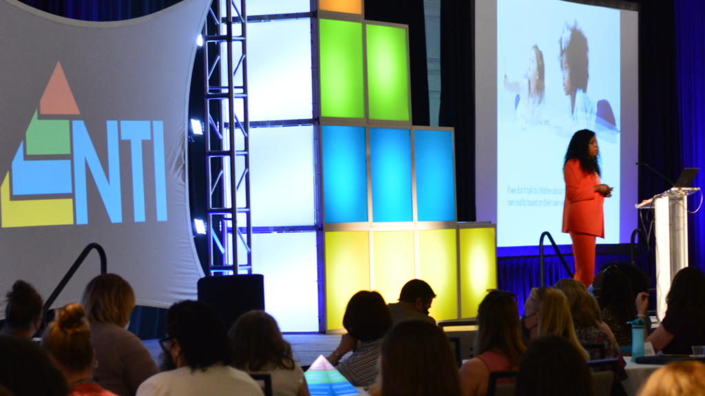 Keynote presenter on stage in front of seated audience.